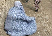 Afghanistan -- A 'burqa' clad Afghan woman begs on a street in Kabul as world observe International Women's Day, 8 Mar. 2006