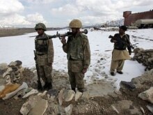 Pakistan -- Pakistani soldiers stand alert with their weapons at an observation post in front of Lwara Fort in the snow covered mountainous region of Alwara Mandei in North Waziristan, 17Feb2007