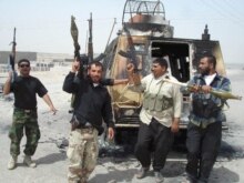 Iraq -- Members of the Imam Al-Mahdi militia pose with their weapons next to a burned police car following clashes in Al-Basrah, 27Mar2008