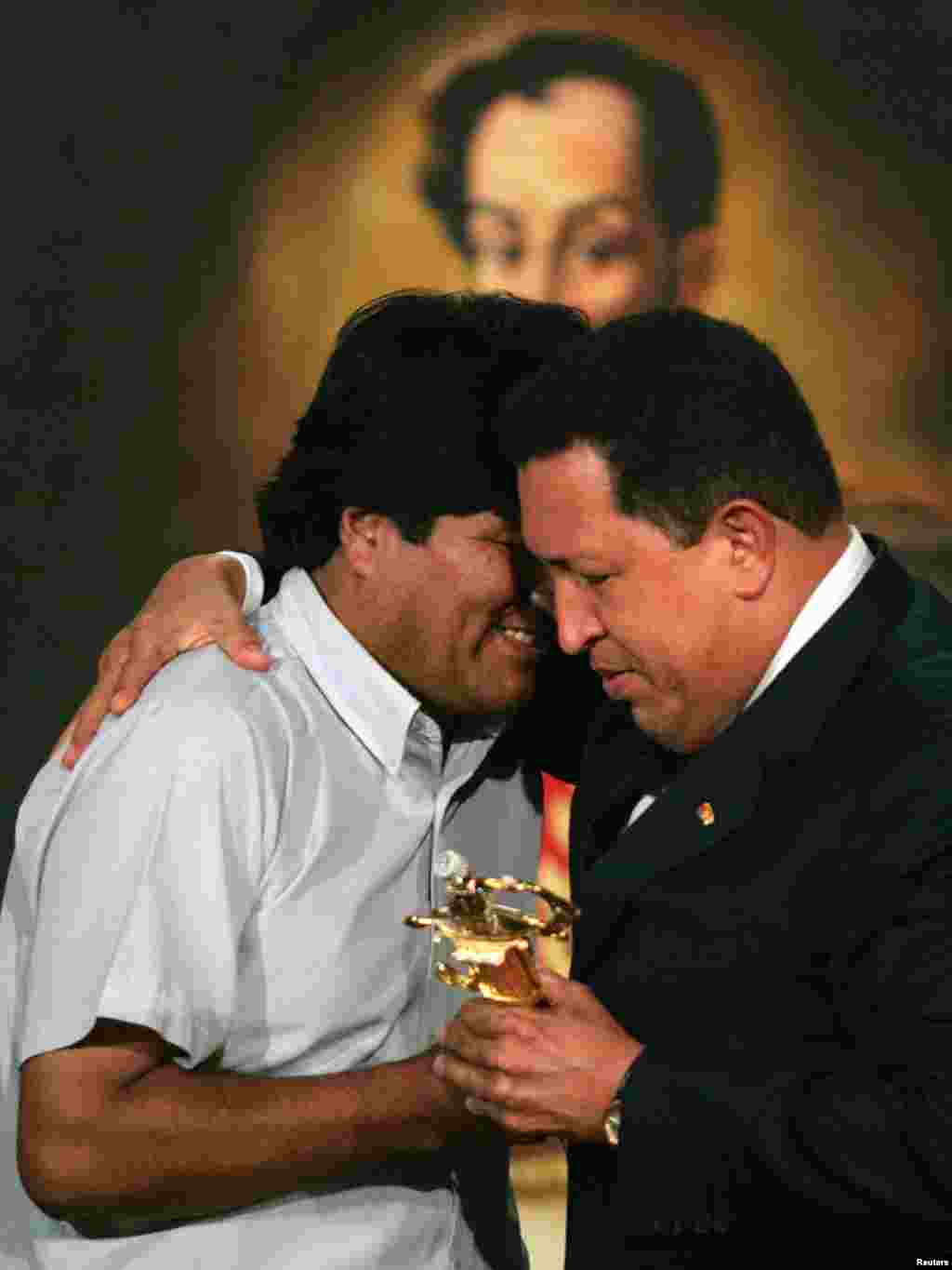 Bolivian President-elect Evo Morales (L) receives a replica of South American independent fighter Simon Bolivar's sword from Venezuelan President Hugo Chavez at the Miraflores Palace in Caracas January 3, 2006. Morales is in Venezuela for a one-day visit. REUTERS/Jorge Silva 