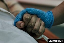 Un medic ține mâna unui soldat ucrainean rănit într-o bătălie cu trupele rusești într-un spital din Nikolaiev, Ucraina, 3 noiembrie 2022.