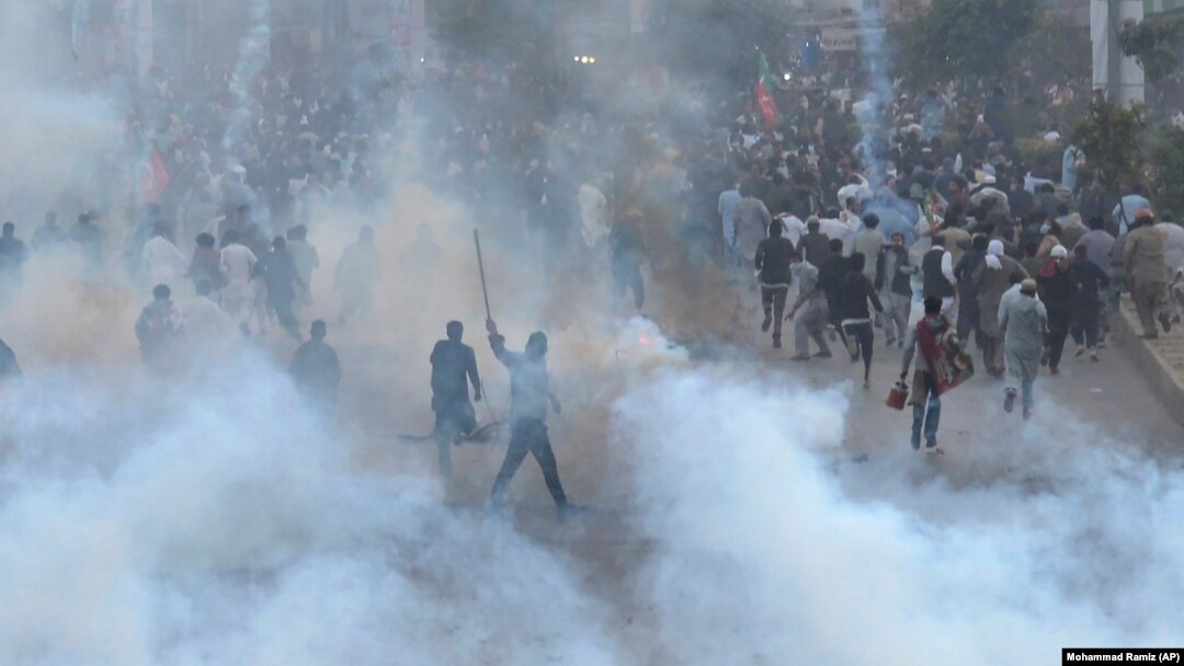 PTI supporters run for cover after police fire a tear gas shell during a protest to condemn an assassination attempt on their leader, former Prime Minister Imran Khan, in Rawalpindi on November 4. 
