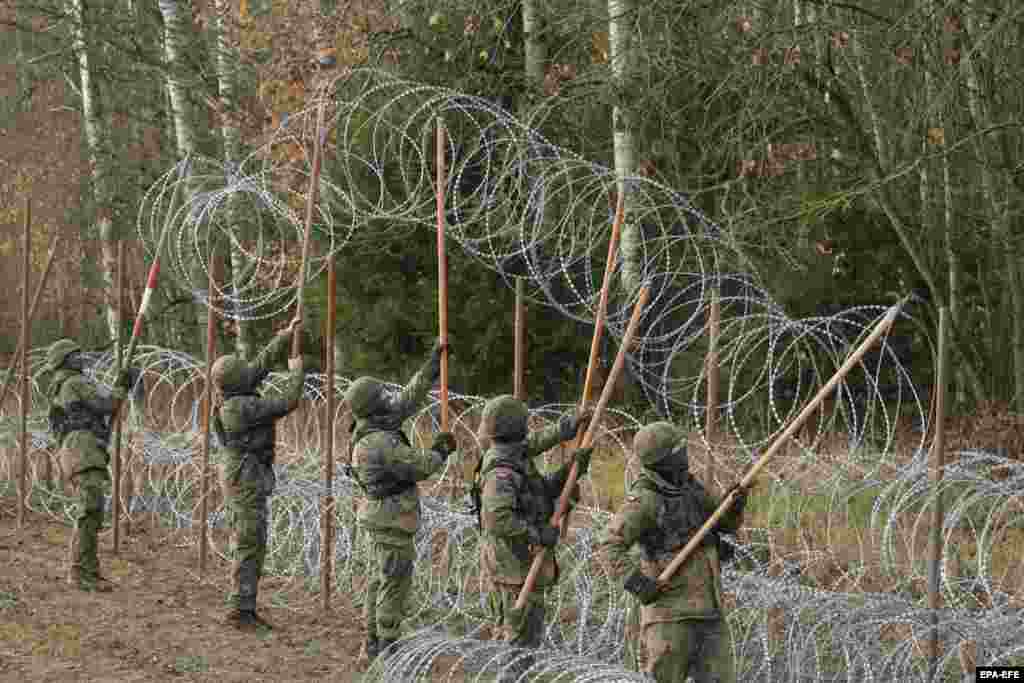 Lengyel katonák szögesdrót kerítést emelnek a határ mentén. 2021-ben, amikor Belarusz menekülteket eresztett az EU területére &ndash; az EU tisztviselői szerint zsarolásként a szankciók miatt &ndash;, a hónapokig tartó patthelyzet humanitárius katasztrófához vezetett, amelyben 21 menekült életét vesztette