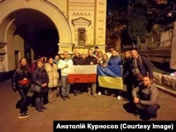 Учасники акції із вшанування пам'яті польських діячів на Байковому кладовищі у Києві. 1 листопада 2022 року