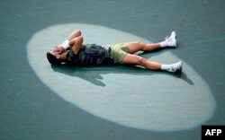  Холгер Руне лежи на корта в Париж, момент откакто е победил Новак Джокович на финала. 