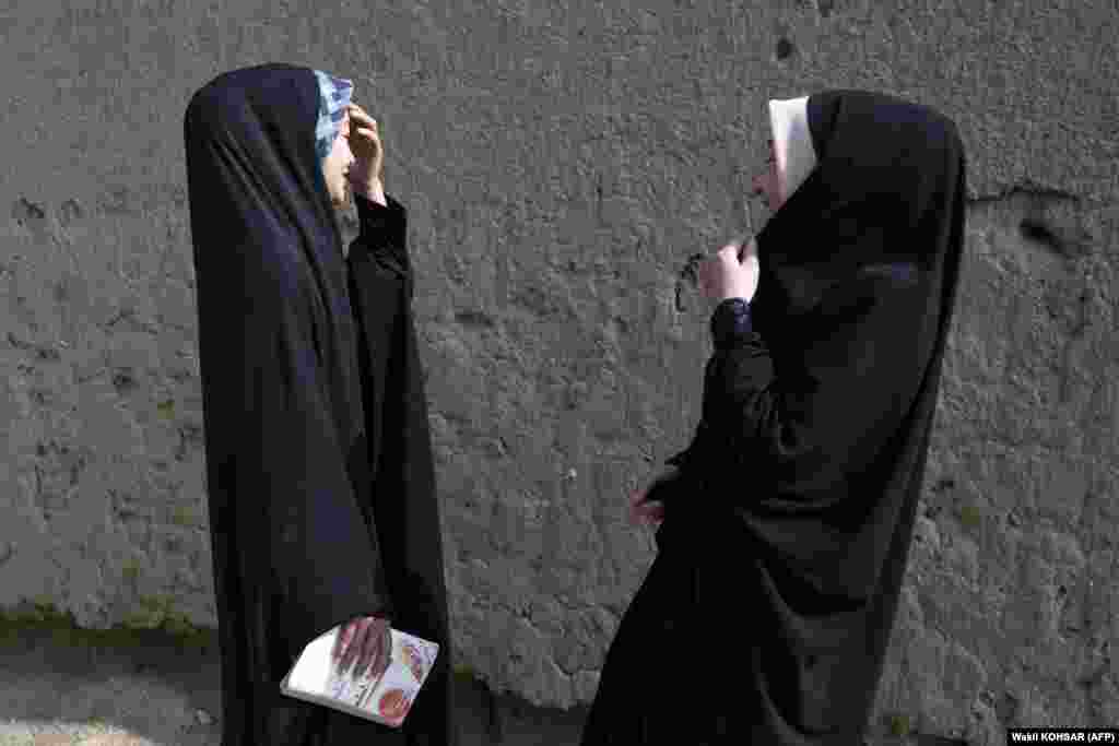 Two Afghan Hazara girls talk in the street in Kabul&#39;s Dasht-e Barchi district.