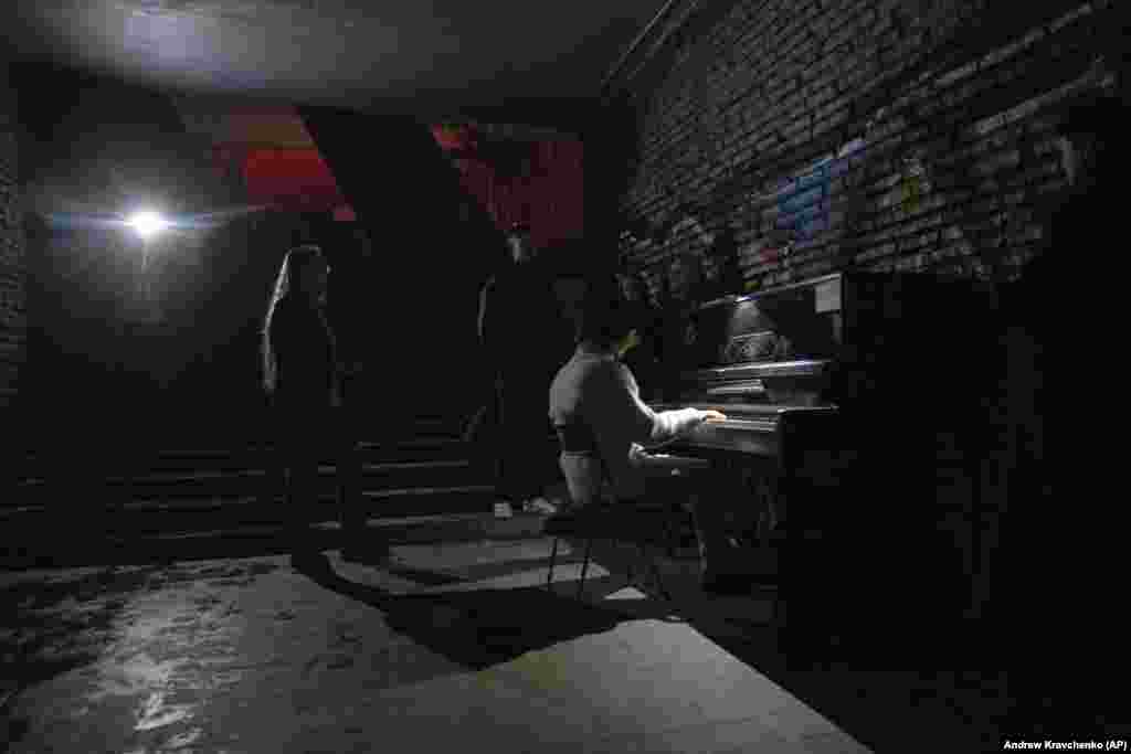 A person plays piano in a street underpass amid a blackout in Kyiv.