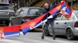 A man holds Serbian flags in North Mitrovica, Kosovo, following local Serbs' decision to quit their jobs in Kosovar institutions in November 2022.