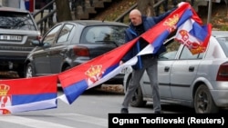 A man holds Serbian flags in North Mitrovica, Kosovo, following local Serbs' decision to quit their jobs in Kosovar institutions in November 2022.