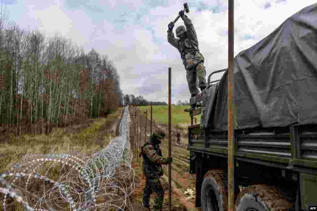 Польские военные вбивают в землю столб для установки забора на границе с Калининградской областью России &nbsp;