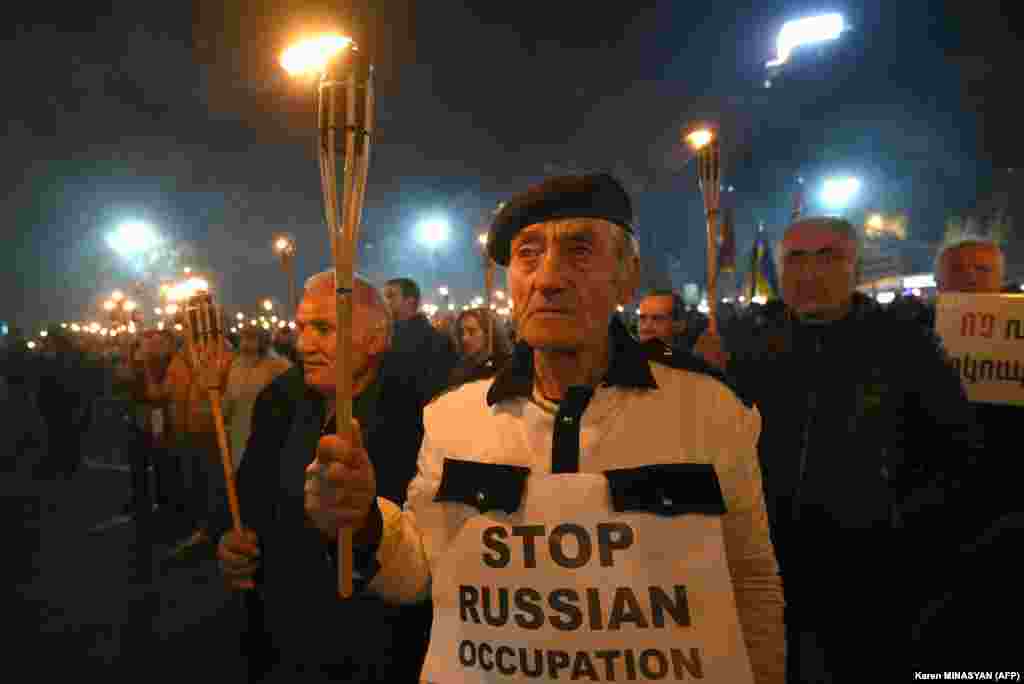 Armenian opposition supporters march with torches during an anti-Russian rally in Yerevan against Russia&#39;s policy in the Nagorno-Karabakh conflict and its military action in Ukraine.