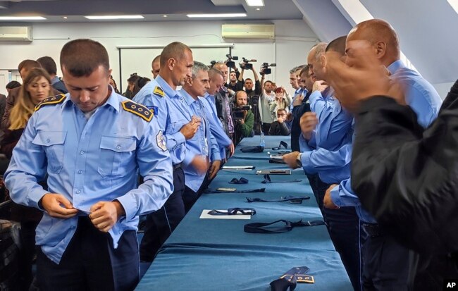 Aleksandar Filipoviq, i pari në anën e majtë të fotografisë, shihet duke hequr uniformën e Policisë së Kosovës.