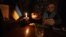 A bartender pours a drink by candlelight during a power cut at a bar in the center of Ukrainian capital of Kyiv. 