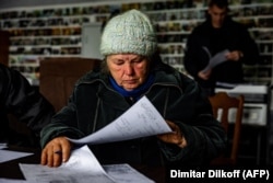 78-летняя Анна Сухова заполняет документы, чтобы подтвердить личность погибшего брата