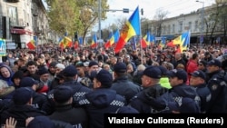 Полицейские блокируют улицу во время антиправительственной акции протеста в Кишиневе, Молдова, 23 октября 2022 года