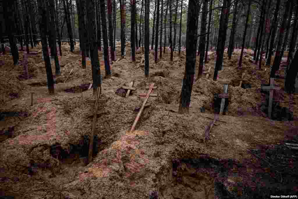 A November 4 photo shows empty graves in a forest in Izyum after the exhumation of bodies by Ukrainian war crimes investigators. Izyum was occupied by Russian forces from April until early September when a massive Ukrainian counteroffensive pushed the invading army out of the Kharkiv region.