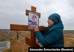 Irina Orfinyak unokája, Veronika sírjánál a Mariupoltól északnyugatra fekvő Sztarokrimszke temetőben november 9-én. A gyermek édesapjával együtt halt meg, amikor a város orosz ostroma alatt egy aknavető lövedéke a kint főző emberek közé csapódott. Irina szerint tíz ember halt meg az akna felrobbanásakor, köztük három gyermek