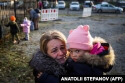 Svetlana Titova, de 52 de ani, o ține în brațe pe nepoata sa la ajungerea într-un centru umanitar din Zaporojie. Ele au fugit din Berdiansk, oraș controlat de forțele Rusiei. 7 noiembrie 2022