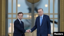 Президент Турции Тайип Эрдоган и премьер-министр Швеции Ульф Кристерссон позируют после церемонии приветствия в Президентском дворце в Анкаре, Турция, 8 ноября 2022 года