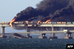 Tűz az orosz szárazföldet a Krímmel összekötő Kercsi hídon 2022. október 8-án. Moszkva bejelentése szerint egy teherautó felrobbanása okozta a pusztítást