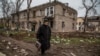 Місцева жителька йде вулицею біля зруйнованого російськими обстрілами будинку, Сіверськ, Донецька область, 6 листопада 2022 року. Фото ілюстративне