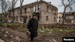 Місцева жителька йде вулицею біля зруйнованого російськими обстрілами будинку, Сіверськ, Донецька область, 6 листопада 2022 року. Фото ілюстративне