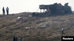 Emergency personnel stand near a destroyed fire engine and bodies at the scene of a large explosion at a military base in southern Cyprus.