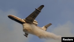 A Russian Emergencies Ministry airplane drops water over a forest fire outside the town of Shatura, southeast of Moscow, on August 12.