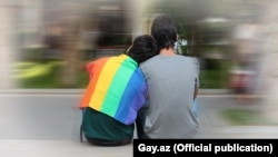ЛГБТ (лесби, гей, бисексуал, трансгендер) символы бейнеленген матаны жамылып отырған адамдар. (Көрнекі сурет)