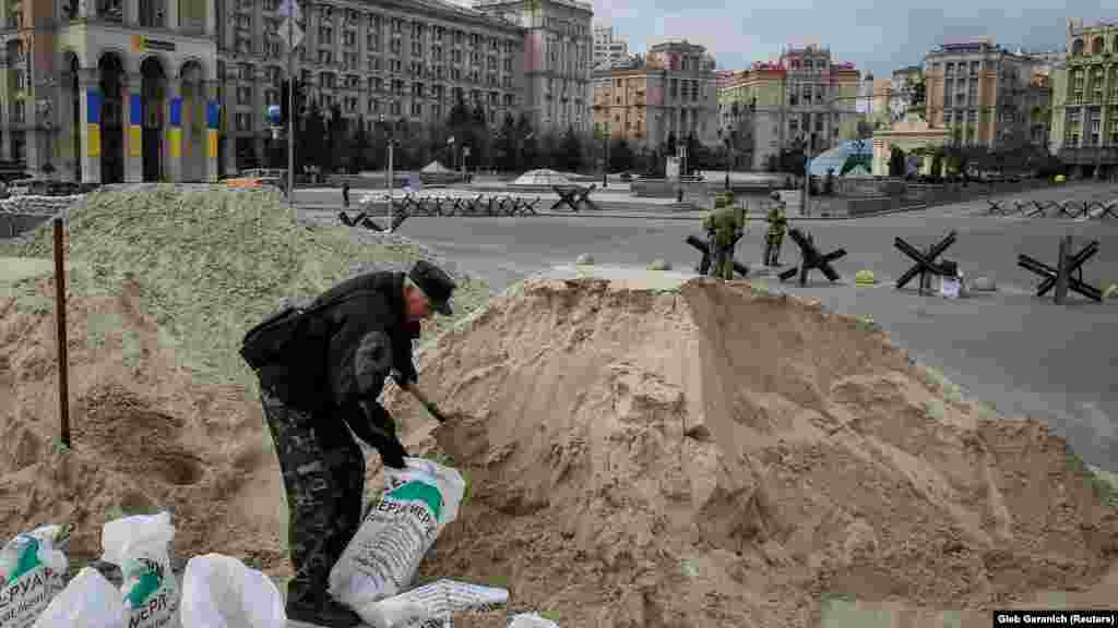 Мужчина наполняет мешки песком во время подготовки к обороне Киева, Фото было сделано в марте 2022 года, когда украинская столица была окружена российскими войсками.