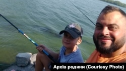 Микита Левченко за батьком на риболовлі. Архів родини