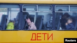 Az orosz ellenőrzés alatt álló Herszon városból evakuált gyerekek várakoznak egy Krímbe tartó buszon 2022. október végén
