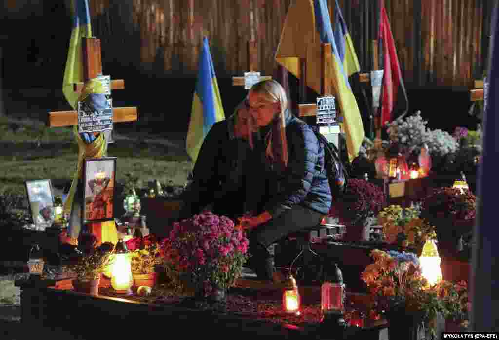 Ukrainians light candles as they visit the graves of Ukrainian soldiers killed in the war with Russia at a cemetery in Lviv in western Ukraine on All Saint&#39;s Day and the Day of the Dead.