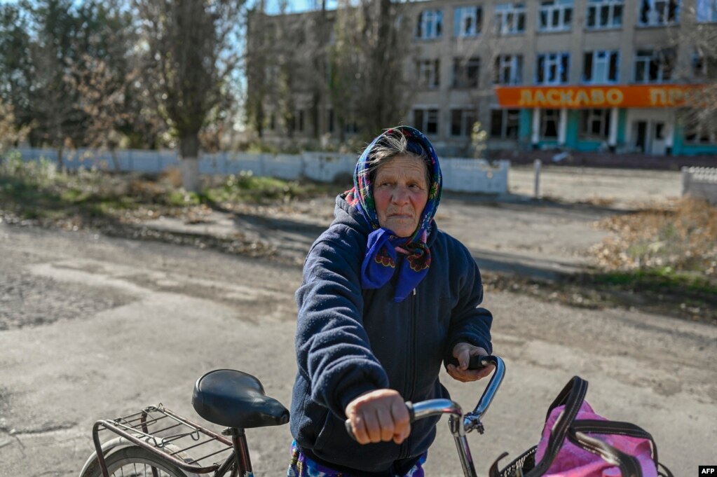 A woman holds her bicycle near a damaged school building in a village outside Mykolayiv on November 1.
Fresh Strikes