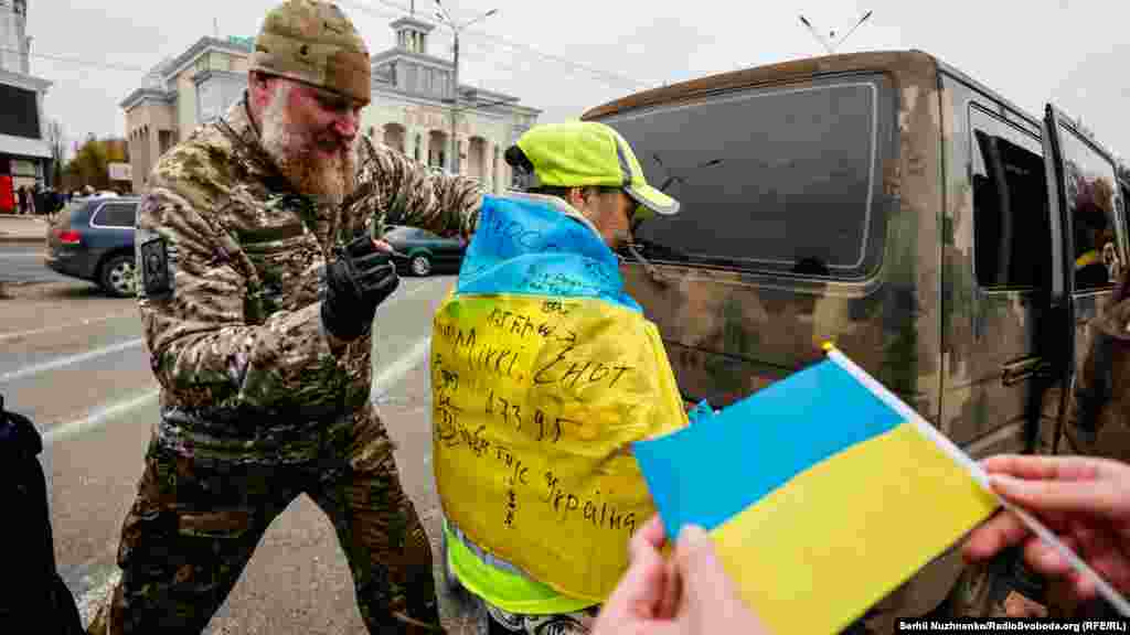 Војник се потпишува на украинско знаме во центарот на Херсон.&nbsp;