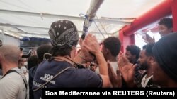 Migranti na brodu Ocean Viking aplaudiraju nakon pristanka Francuske da odobri usidrenje broda, 10. novembar 2022. 