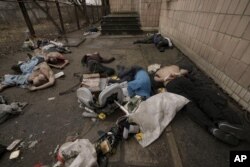 Cadavrele unor bărbați, unii cu mâinile legate la spate, zac pe jos în Bucea, Ucraina, 3 aprilie 2022.