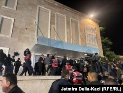 Protestuesit duke thyer kordonin e Policisë së Shqipërisë para ndërtesës së Qeverisë.