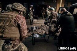 Українські військові несуть пораненого в госпіталь у Бахмуті Донецької області