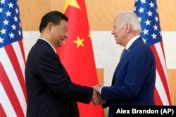 Xi Jinping și Joe Biden își strâng mâinile înainte de întâlnirea avută în marja summitului G20 de la Nusa Dua, stațiunea indoneziană de pe insula Bali, 14 noiembrie 2022.