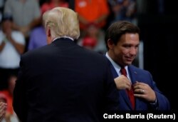 Ron DeSantis se pregătește să vorbească în timpul unui miting de campanie alături de Donald Trump, Florida, 31 octombrie 2018.