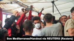 Migranții fericiți după ce s-a decis ca Toulon, Franța, să fie portul pentru debarcarea lor, de la bordul navei de salvare „Ocean Viking", în Marea Mediterană, 10 noiembrie 2022