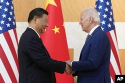 Президент США Джо Байден (справа) и председатель КНР Си Цзиньпин обмениваются рукопожатием перед встречей в кулуарах саммита G20, 14 ноября 2022