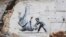 O posibilă lucrare a artistului britanic stradal Banksy pe zidul unei clădiri distruse de lupte la Borodianka, regiunea Kiev, 13 noiembrie 2022.