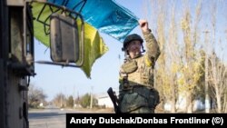 Войник държи украинско знаме в град Снигуривка, близо до Херсон, 10 ноември 2022 г.
