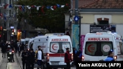 Ambulances line up as Turkish policemen try to secure the area after an explosion shook the busy shopping street of Istiklal in Istanbul on November 13, 2022.