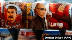 Сталин, Путин ва Ленин суратлари туширилган сувенир кружкалар.