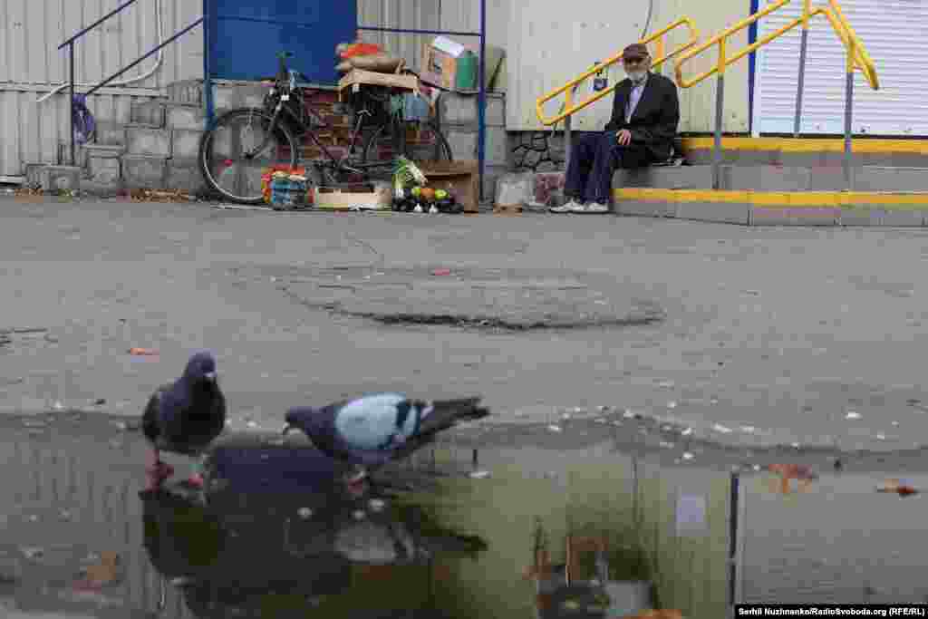 Un bărbat vinde fructe și legume cultivate pe propriul teren lângă un supermarket închis din Pokrovsk.