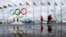 People walk past the Olympic rings beside Sochi's Olympic Park amid preparations continue for this year's Winter Games. 