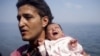 A Syrian refugee from Aleppo holds his 1-month-old daughter moments after arriving on a dinghy on the Greek island of Lesbos on September 3.